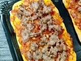 Coca al romero con tomate, piñones y butifarra de cebolla caramelizada
