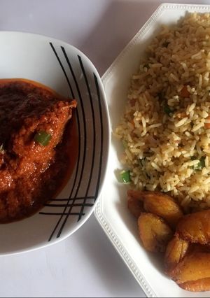 A picture of Stir fried rice, chicken stew and fried plantain.