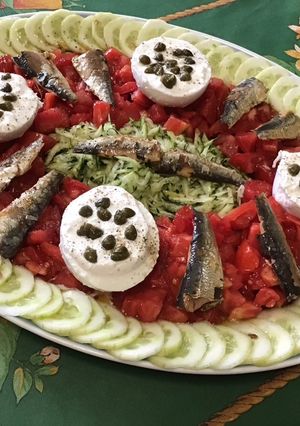 Une photo de Salade de tomates, courgette et concombre aux sardines, câpres et mozzarella sauce malt