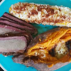 A picture of Smoked brisket, elote (Mexican corn) smoked sweet potato.