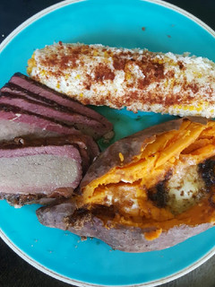 A picture of Smoked brisket, elote (Mexican corn) smoked sweet potato.