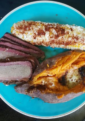 A picture of Smoked brisket, elote (Mexican corn) smoked sweet potato.