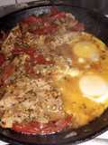 Bifes de cerdo a la portuguesa y huevos cocinados en su jueguito
