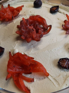 Una foto de Postre de mascarpone con arándanos azules, frambuesas, granada y flores de hibiscus deshidratada