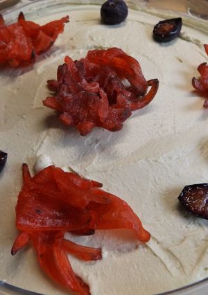 Una foto de Postre de mascarpone con arándanos azules, frambuesas, granada y flores de hibiscus deshidratada
