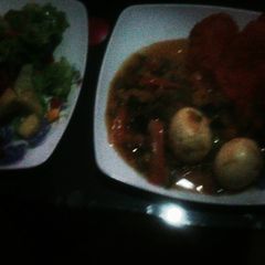 A picture of Egg curry and lettuce / pineapple salad.