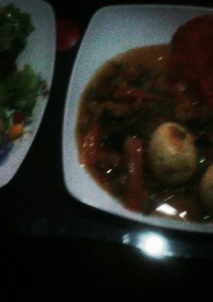 A picture of Egg curry and lettuce / pineapple salad.