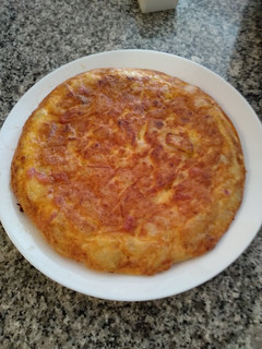 Una foto de Tortilla de patatas con bacon, sobre lonchas de jamón serrano