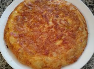 Foto principal de Tortilla de patatas con bacon, sobre lonchas de jamón serrano