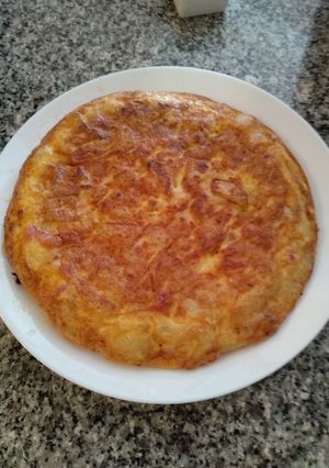 Una foto de Tortilla de patatas con bacon, sobre lonchas de jamón serrano