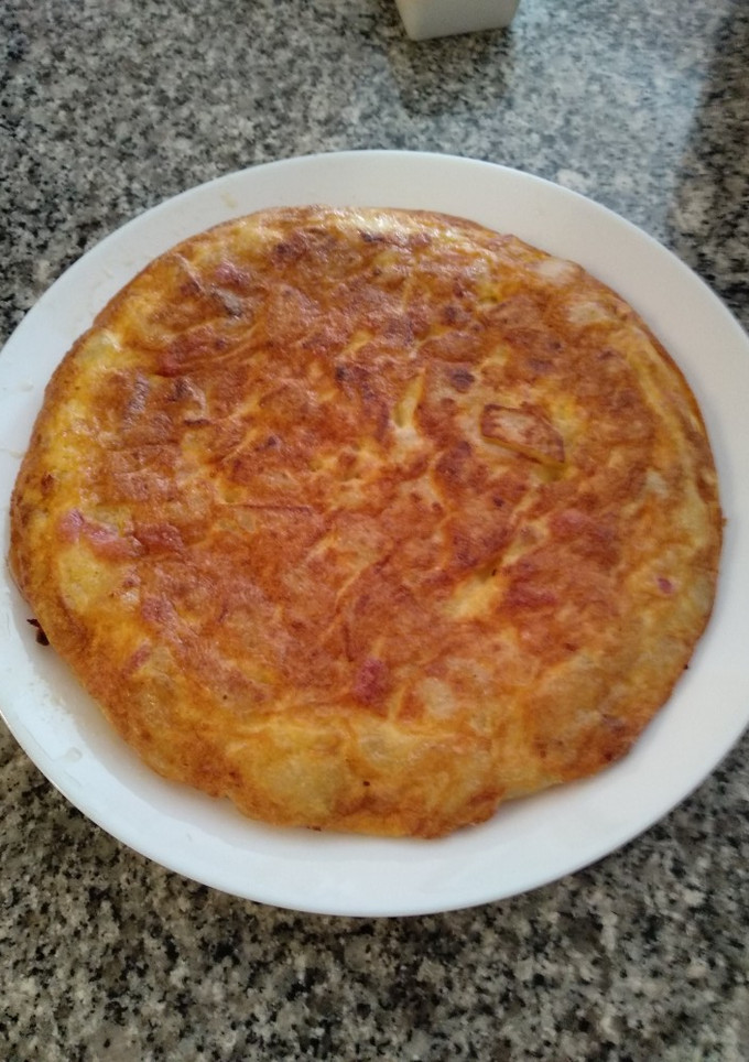 Una foto de Tortilla de patatas con bacon, sobre lonchas de jamón serrano
