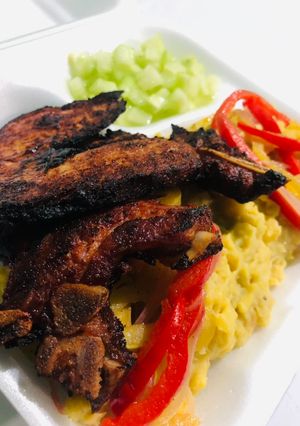 Una foto de Mangú de plátano con chuleta y vegetales salteando