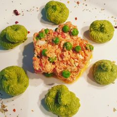 A picture of Scrambled eggs with tomato and mashed avocados.