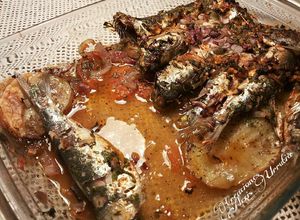 Foto principal de Sardinas marinadas al horno, con fondo de tomates, cebollas, y patatas asadas