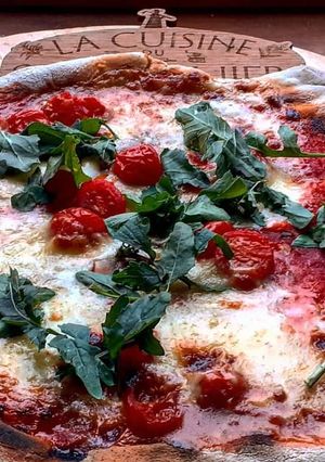Une photo de Pizza tomates cerises et roquette