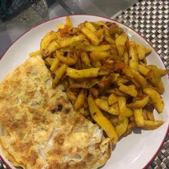 A picture of Chips and egg wit stir fry veggies.
