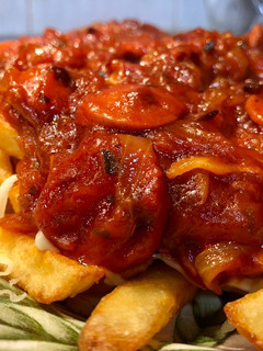 Una foto de Salchichas con patatas fritas, tomate y queso