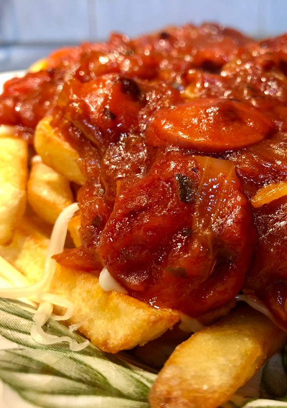 Una foto de Salchichas con patatas fritas, tomate y queso