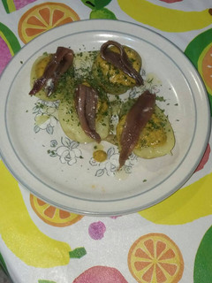 Una foto de Patatas con salsa de tomate, ajo y perejil con anchoas