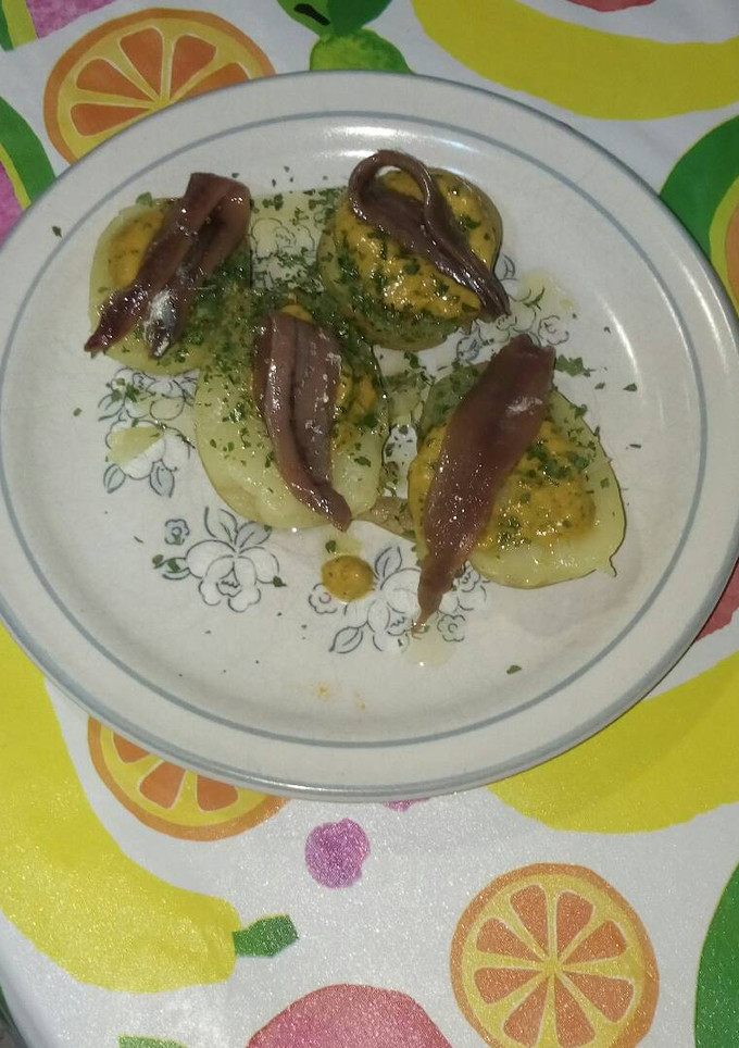 Una foto de Patatas con salsa de tomate, ajo y perejil con anchoas