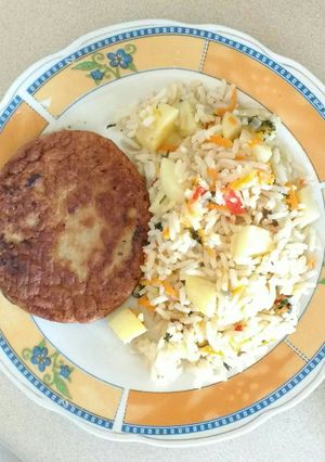 Una foto de Arroz con papas y hamburguesa de carne vegetal