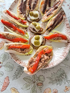 Una foto de Endivias de atún con pimientos y chasca con anchoas con tomate, queso de cabra y aceitunas