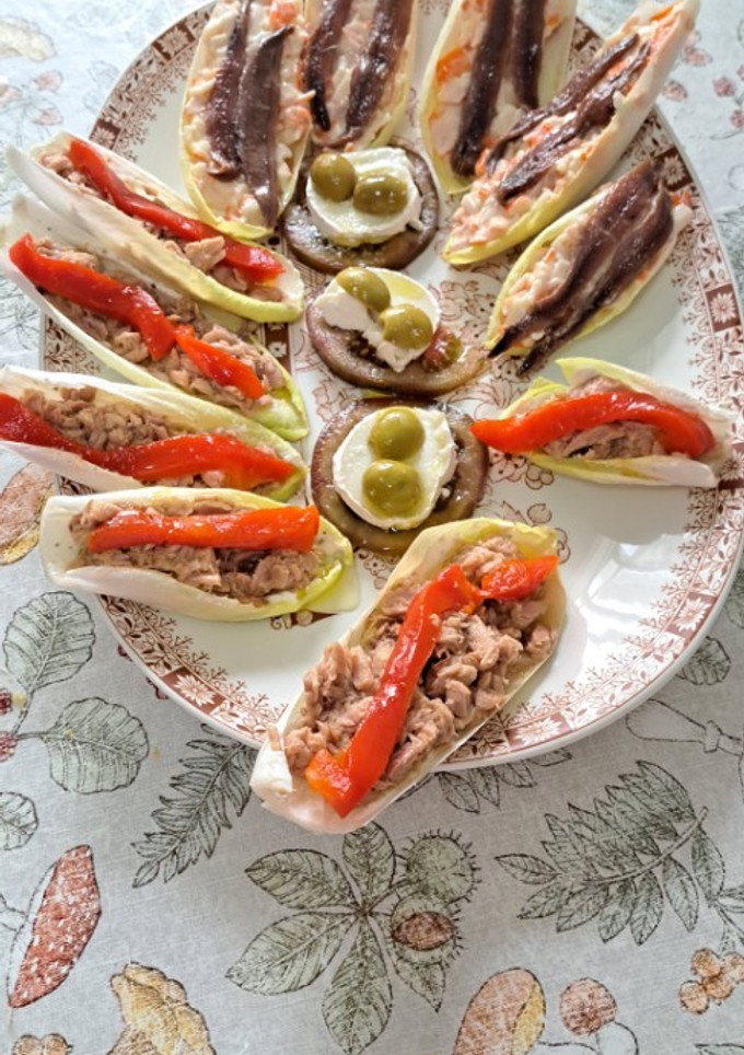 Una foto de Endivias de atún con pimientos y chasca con anchoas con tomate, queso de cabra y aceitunas