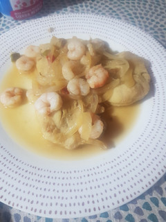Una foto de Medallón de merluza con gambas y cebolla