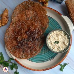 A picture of Multi grain flour dosa with mint leaves.