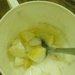 A picture of Yogurt with sliced apple n banana.
