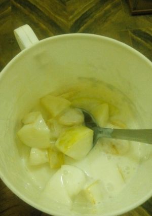 A picture of Yogurt with sliced apple n banana.