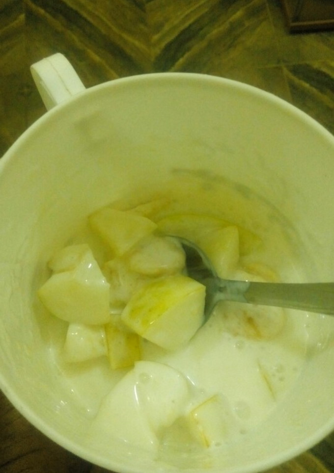 A picture of Yogurt with sliced apple n banana.