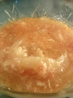 Una foto de Encebollado tomate y huevo