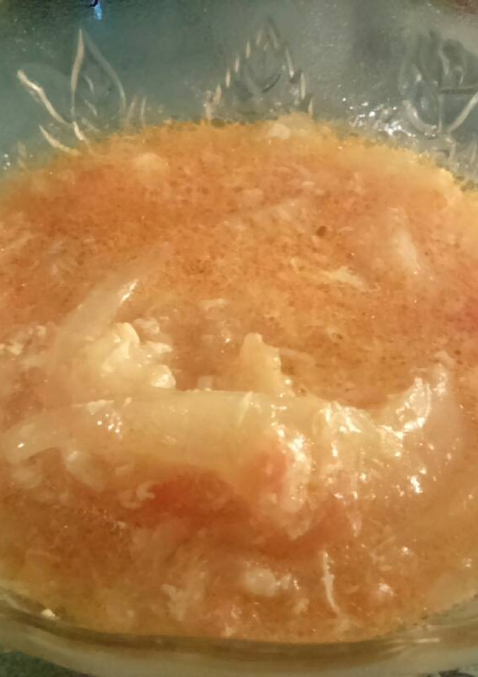 Una foto de Encebollado tomate y huevo