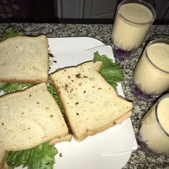 A picture of Suya sandwich and orange banana smoothie.