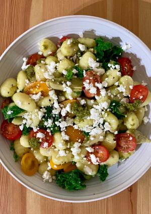 A picture of Gnocchi with pesto, artichoke, tomatoes and feta.