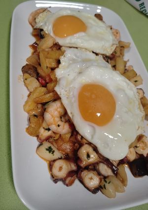 Una foto de Pulpo al ajillo con base de patatas y verdura con huevos a la plancha