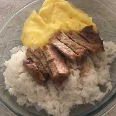 A picture of Bife de cerdo con puré y arroz.