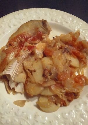 Una foto de Filet de merluza con papas y cebolla