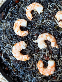 Una foto de Arroz negro con gulas y langostinos