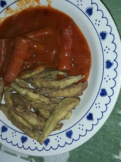 Una foto de Salchichas big queso con berenjena fritas y tomate