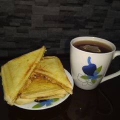 A picture of Scrambled egg toast and tea.