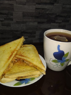 A picture of Scrambled egg toast and tea.