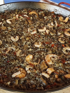 Una foto de Arroz negro con rape y calamar al alioli a la leña
