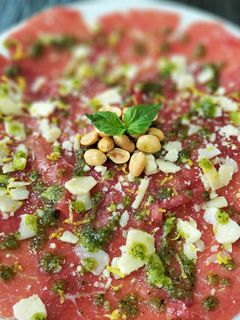 Una foto de Carpaccio de vacuno trufado con parmesano y pesto de cacahuetes
