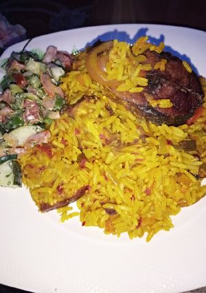 A picture of Palm oil Jealof rice With salad.