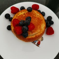 A picture of Souffle pancake with berries and wild honey.