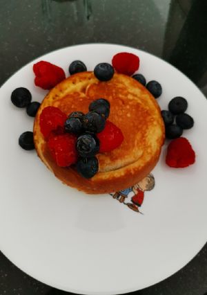 A picture of Souffle pancake with berries and wild honey.