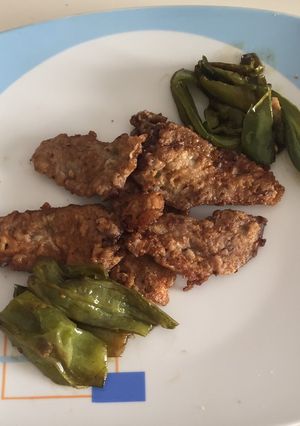 Una foto de Solomillo de ciervo rebozado con piperrada de pimientos verdes y rojos
