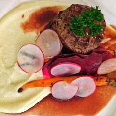 A picture of Fillet of beef with parsnip and macadamia purée with seasonal vegetables.